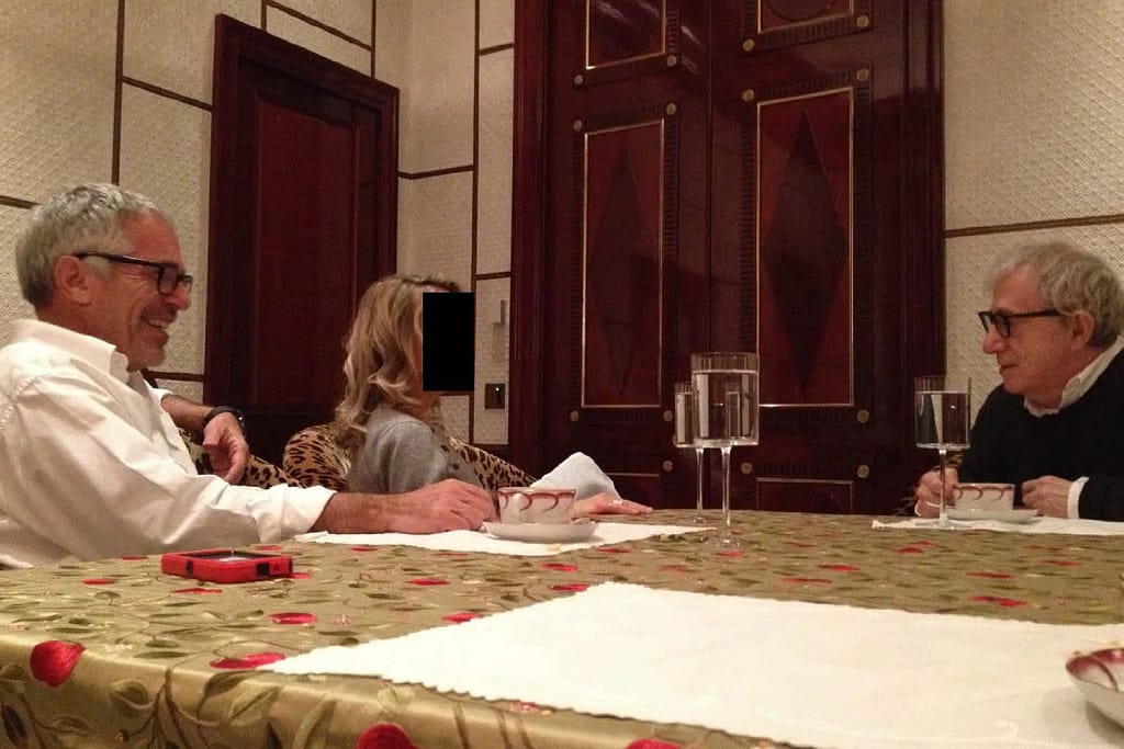 Image depicting Jeffrey Epstein inside an office-like setting with framed photos visible in the background.